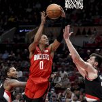 
              Houston Rockets guard Jalen Green, center, drives to the basket as Portland Trail Blazers guard Ben McLemore, left, and forward Drew Eubanks defend during the first half of an NBA basketball game in Portland, Ore., Saturday, March 26, 2022.(AP Photo/Steve Dykes)
            