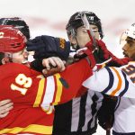 
              Referees try to break it up as Edmonton Oilers' Evander Kane, right, mixes it up with Calgary Flames' Matthew Tkachuk during second-period NHL hockey game action in Calgary, Alberta, Monday, March 7, 2022. (Larry MacDougal/The Canadian Press via AP)
            