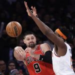 
              Chicago Bulls center Nikola Vucevic (9) passes the ball around New York Knicks center Mitchell Robinson during the first half of an NBA basketball game Monday, March 28, 2022, in New York. (AP Photo/Adam Hunger)
            
