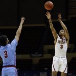 
              Loyola (La.) guard Myles Burns, right, hits a 3-0pointer as Talladega guard Darryl Baker defends during the first half of the NAIA men's championship college basketball game Tuesday, March 22, 2022, in Kansas City, Mo. (AP Photo/Colin E. Braley)
            