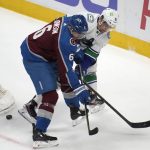 
              Colorado Avalanche defenseman Erik Johnson, left, and Vancouver Canucks left wing Juho Lammikko vie for the puck during the first period of an NHL hockey game Wednesday, March 23, 2022, in Denver. (AP Photo/David Zalubowski)
            