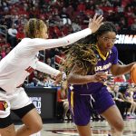 
              Albany guard Kayla Cooper (20) drives past Louisville guard Ahlana Smith (2) during the first half of their women's NCAA Tournament college basketball first round game in Louisville, Ky., Friday, March 18, 2022. (AP Photo/Timothy D. Easley)
            