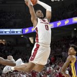 
              Arkansas guard Stanley Umude (0) dunks the ball over LSU forward Shareef O'Neal, right, during the first half of an NCAA college basketball game Wednesday, March 2, 2022, in Fayetteville, Ark. (AP Photo/Michael Woods)
            