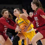 
              Michigan's Amy Dilk heads to the basket as South Dakota's Kyah Watson (32) and Chloe Lamb, right, defend during the second half of a college basketball game in the Sweet 16 round of the NCAA women's tournament Saturday, March 26, 2022, in Wichita, Kan. (AP Photo/Jeff Roberson)
            