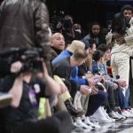
              Brooklyn Nets' Kyrie Irving, right, greets people as he enters the arena during the first half of the NBA basketball game between the Brooklyn Nets and the New York Knicks at the Barclays Center, Sunday, Mar. 13, 2022, in New York. (AP Photo/Seth Wenig)
            