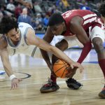 
              UCLA's Jules Bernard, left, and Washington State's Noah Williams scramble for the ball during the first half of an NCAA college basketball game in the quarterfinal round of the Pac-12 tournament Thursday, March 10, 2022, in Las Vegas. (AP Photo/John Locher)
            