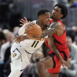 
              Denver Nuggets guard Monte Morris, left, drives to the basket as Toronto Raptors guard Armoni Brooks defends in the first half of an NBA basketball game Saturday, March 12, 2022, in Denver. (AP Photo/David Zalubowski)
            