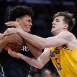 
              Dallas Mavericks guard Josh Green, left, and Los Angeles Lakers guard Austin Reaves grapple for the ball during the first half of an NBA basketball game Tuesday, March 1, 2022, in Los Angeles. (AP Photo/Mark J. Terrill)
            
