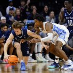 
              St. Peter's Doug Edert, left, and North Carolina's Leaky Black battle for a loose ball during the first half of a college basketball game in the Elite 8 round of the NCAA tournament, Sunday, March 27, 2022, in Philadelphia. (AP Photo/Matt Rourke)
            