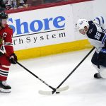 
              Chicago Blackhawks center Jonathan Toews, left, and Winnipeg Jets defenseman Nate Schmidt battle for the puck during the second period of an NHL hockey game in Chicago, Sunday, March 20, 2022. (AP Photo/Nam Y. Huh)
            
