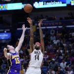 
              New Orleans Pelicans forward Brandon Ingram (14) shoots against Los Angeles Lakers guard Austin Reaves (15) in the second half of an NBA basketball game in New Orleans, Sunday, March 27, 2022. The Pelicans won 116-108. (AP Photo/Gerald Herbert)
            
