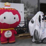 
              A man deflates Winter Olympics mascot Bing Dwen Dwen near the Winter Paralympics mascot Shuey Rhon Rhon on Sunday, March 13, 2022, in Beijing. The Paralympics will close Sunday completing the Chinese capital hosting of the 2022 Winter Games. (AP Photo/Ng Han Guan)
            