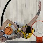 
              Villanova guard Collin Gillespie shoots over Michigan forward Brandon Johns Jr. during the second half of a college basketball game in the Sweet 16 round of the NCAA tournament on Thursday, March 24, 2022, in San Antonio. (AP Photo/Eric Gay)
            