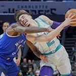 
              Charlotte Hornets guard LaMelo Ball, right, drives into the lane against Denver Nuggets guard Davon Reed, left, during the first half of an NBA basketball game on Monday, March 28, 2022, in Charlotte, N.C. (AP Photo/Rusty Jones)
            