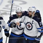 
              Winnipeg Jets right wing Blake Wheeler, right, celebrates with defenseman Neal Pionk, center, and center Mark Scheifele after scoring during the shootout against the Buffalo Sabres during an NHL hockey game in Buffalo, N.Y., Wednesday, March 30, 2022. (AP Photo/Adrian Kraus)
            