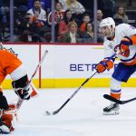 
              New York Islanders' Kyle Palmieri, right, takes a shot against Philadelphia Flyers' Carter Hart during the third period of an NHL hockey game, Sunday, March 20, 2022, in Philadelphia. (AP Photo/Matt Slocum)
            