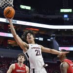 
              Virginia forward Kadin Shedrick (21) goes in for a lay-up past Louisville forward Malik Williams (5) during the first half of an NCAA college basketball game in Louisville, Ky., Saturday, March 5, 2022. (AP Photo/Timothy D. Easley)
            