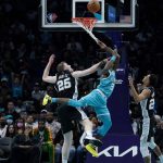 
              Charlotte Hornets guard Terry Rozier scores between San Antonio Spurs center Jakob Poeltl and guard Devin Vassell during the second half of an NBA basketball game on Saturday, March 5, 2022, in Charlotte, N.C. (AP Photo/Chris Carlson)
            