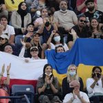 
              Fans hold a Ukraine national flag next to a Polish flag during a semifinal tennis match between Russia's Andrey Rublev and Poland's Hubert Hurkacz at the Dubai Duty Free Tennis Championship in Dubai, United Arab Emirates, Feb. 25, 2022. (AP Photo/Kamran Jebreili)
            