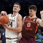 
              Notre Dame's Nate Laszewski (14) drives against Virginia Tech's Hunter Cattoor (0) in the second half of an NCAA college basketball game during quarterfinals of the Atlantic Coast Conference men's tournament, Thursday, March 10, 2022, in New York. (AP Photo/John Minchillo)
            