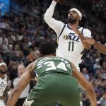 
              Utah Jazz guard Mike Conley (11) shoots as Milwaukee Bucks forward Giannis Antetokounmpo (34) defends during the first half of an NBA basketball game Monday, March 14, 2022, in Salt Lake City. (AP Photo/Rick Bowmer)
            