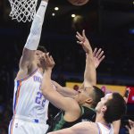 
              Boston Celtics guard Derrick White, center, tries to shoot past Oklahoma City Thunder center Isaiah Roby, left, and forward Aleksej Pokusevski, right, in the second half of an NBA basketball game, Monday, March 21, 2022, in Oklahoma City. (AP Photo/Kyle Phillips)
            
