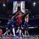 
              Chicago Bulls' DeMar DeRozan, center, goes up for a shot between Philadelphia 76ers' Joel Embiid, left, and Georges Niang during the first half of an NBA basketball game, Monday, March 7, 2022, in Philadelphia. (AP Photo/Matt Slocum)
            
