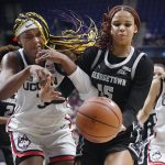 
              Connecticut's Aaliyah Edwards, left, and Georgetown's Brianna Scott, right, fight for the ball in the second half of an NCAA college basketball game in the Big East tournament quarterfinals at Mohegan Sun Arena, Saturday, March 5, 2022, in Uncasville, Conn. (AP Photo/Jessica Hill)
            