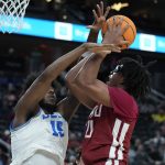 
              UCLA's Myles Johnson (15) guards Washington State's Dishon Jackson (21) during the first half of an NCAA college basketball game in the quarterfinal round of the Pac-12 tournament Thursday, March 10, 2022, in Las Vegas. (AP Photo/John Locher)
            