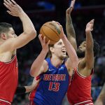 
              Detroit Pistons forward Kelly Olynyk (13) is defended by Chicago Bulls center Nikola Vucevic, left, and guard Coby White during the first half of an NBA basketball game, Wednesday, March 9, 2022, in Detroit. (AP Photo/Carlos Osorio)
            