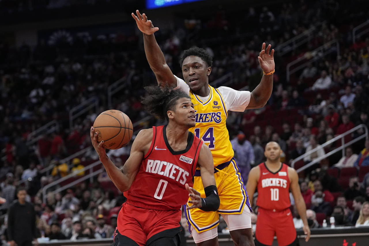 Houston Rockets' Jalen Green (0) goes up for a shot asw Los Angeles Lakers' Stanley Johnson (14) de...