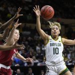 
              Baylor guard Jaden Owens (10) tries to bring in a rebound in front of Oklahoma guard Gabby Gregory (12) and Baylor center Queen Egbo, left, during the second half of an NCAA college basketball game in the semifinal round of the Big 12 Conference tournament in Kansas City, Mo., Saturday, March 12, 2022. (AP Photo/Reed Hoffmann)
            