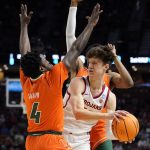 
              Southern California guard Drew Peterson looks to pass between Miami guard Bensley Joseph and guard Kameron McGusty during the first half of a college basketball game in the first round of the NCAA tournament on Friday, March 18, 2022, in Greenville, S.C. (AP Photo/Chris Carlson)
            