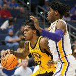 
              LSU forward Mwani Wilkinson, right, collides with Missouri guard DaJuan Gordon as he pulls up during the second half of an NCAA men's college basketball game at the Southeastern Conference tournament in Tampa, Fla., Thursday, March 10, 2022. (AP Photo/Chris O'Meara)
            