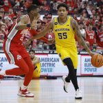 
              Michigan's Eli Brooks, right, brings the ball up the court as Ohio State's Malaki Branham defends during the first half of an NCAA college basketball game, Sunday, March 6, 2022, in Columbus, Ohio. (AP Photo/Jay LaPrete)
            