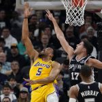 
              Los Angeles Lakers guard Talen Horton-Tucker (5) scores past San Antonio Spurs forward Robert Woodard II (17) during the second half of an NBA basketball game, Monday, March 7, 2022, in San Antonio. (AP Photo/Eric Gay)
            
