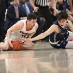 
              Davidson guard Foster Loyer, left, and Richmond guard Andre Gustavson, right, battle for the ball during the first half of an NCAA college basketball game in the championship of the Atlantic 10 conference tournament, Sunday, March 13, 2022, in Washington. (AP Photo/Nick Wass)
            
