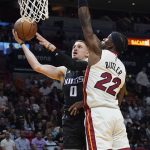 
              Sacramento Kings guard Donte DiVincenzo (0) drives to the basket as Miami Heat forward Jimmy Butler (22) defends during the first half of an NBA basketball game, Monday, March 28, 2022, in Miami. (AP Photo/Marta Lavandier)
            