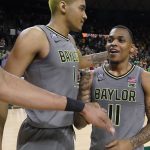 
              Baylor guard James Akinjo (11) is congratulated by forward Flo Thamba (0) and other teammates after an NCAA college basketball game against Iowa State in Waco, Texas, Saturday, March 5, 2022. (AP Photo/LM Otero)
            