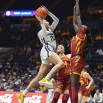 
              West Virginia guard Savannah Samuel (24) shoots while being guarded by Iowa State forward Nyamer Diew (1) during the first half of an NCAA college basketball game in Morgantown, W.Va., Saturday, March 5, 2022. (AP Photo/William Wotring)
            