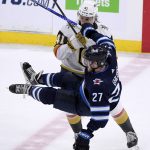 
              Winnipeg Jets' Nikolaj Ehlers (27) is checked by Vegas Golden Knights' Nolan Patrick (41) during the third period of an NHL hockey game in Winnipeg, Manitoba, Tuesday, March 22, 2022. (Fred Greenslade/The Canadian Press via AP)
            