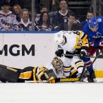 
              Pittsburgh Penguins goaltender Tristan Jarry (35) defends the goal as center Teddy Blueger (53) and New York Rangers center Jonny Brodzinski (76) battle for the puck during the third period of an NHL hockey game, Friday, March 25, 2022, in New York. (AP Photo/John Minchillo)
            