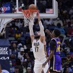 
              New Orleans Pelicans center Jonas Valanciunas (17) slam dunks against Los Angeles Lakers forward Stanley Johnson (14) in the first half of an NBA basketball game in New Orleans, Sunday, March 27, 2022. (AP Photo/Gerald Herbert)
            
