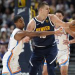 
              Oklahoma City Thunder guard Theo Maledon, left, tries to steal the ball from Denver Nuggets center Nikola Jokic, center, in the first half of an NBA basketball game Saturday, March 26, 2022, in Denver. (AP Photo/David Zalubowski)
            