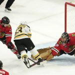 
              Chicago Blackhawks goaltender Marc-Andre Fleury (29) makes a save on a shot by Boston Bruins' Brad Marchand (63) as Dylan Strome also defends during the first period of an NHL hockey game Tuesday, March 15, 2022, in Chicago. (AP Photo/Charles Rex Arbogast)
            