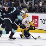 Nashville Predators forward Tanner Jeannot, right, is tripped by Seattle Kraken forward Kole Lind, left rear, while defenseman Vince Dunn knocks the puck away during the third period of an NHL hockey game Wednesday, March 2, 2022, in Seattle. The Kraken won 4-3. (AP Photo/Stephen Brashear)