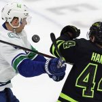 
              Vancouver Canucks right wing Alex Chiasson (39) and Dallas Stars defenseman Joel Hanley (44) try to get control of the puck during the third period of an NHL hockey game in Dallas, Saturday, March 26, 2022. (AP Photo/LM Otero)
            