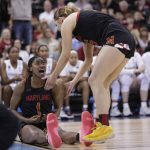 
              Maryland guard Diamond Miller (1) reacts as she is helped up by forward Chloe Bibby, right, during the second half of a college basketball game against Stanford in the Sweet 16 round of the NCAA tournament, Friday, March 25, 2022, in Spokane, Wash. (AP Photo/Young Kwak)
            