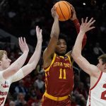 
              Iowa State's Tyrese Hunter passes between Wisconsin's Steven Crowl and Ben Carlson during the first half of a second-round NCAA college basketball tournament game Sunday, March 20, 2022, in Milwaukee. (AP Photo/Morry Gash)
            