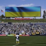
              Soccer fans observe a moment of silence in support of Ukraine before an MLS soccer match between the Los Angeles Galaxy and the New York City FC Sunday, Feb. 27, 2022, in Carson, Calif. (AP Photo/Jae C. Hong)
            